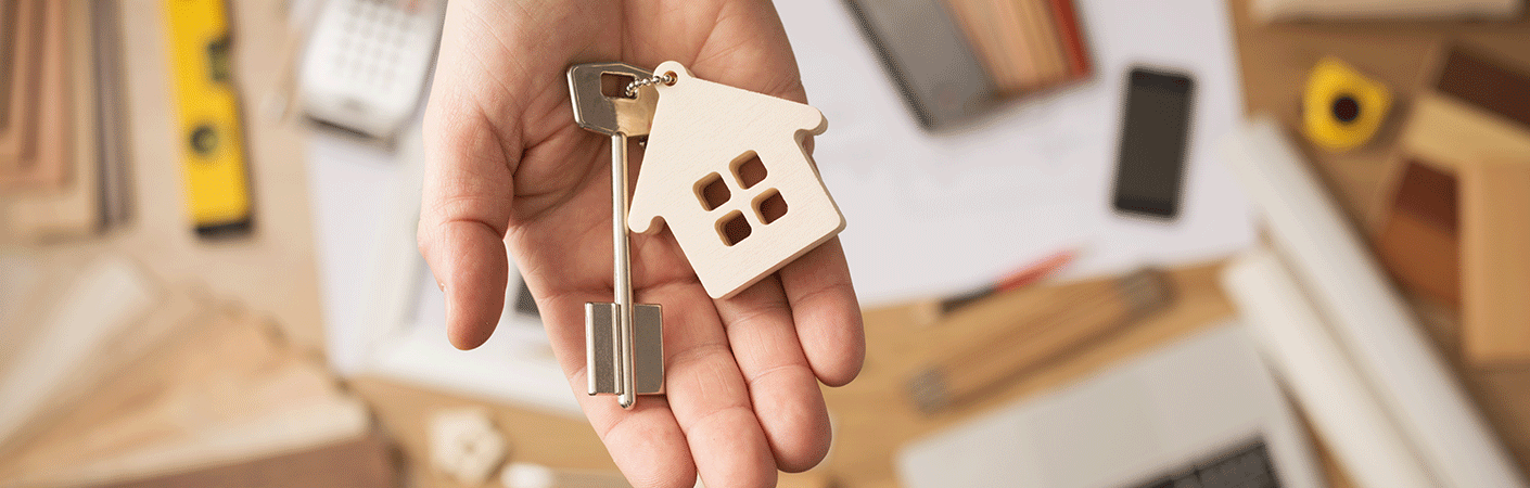 Person holding a key that has a house attached