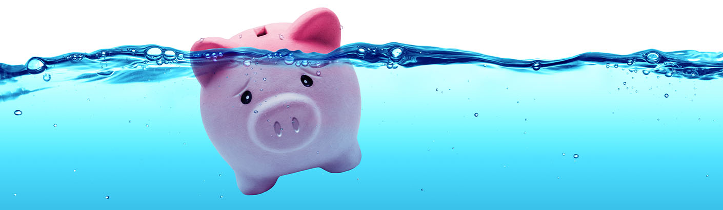 Stressed looking piggy bank submerged in water.